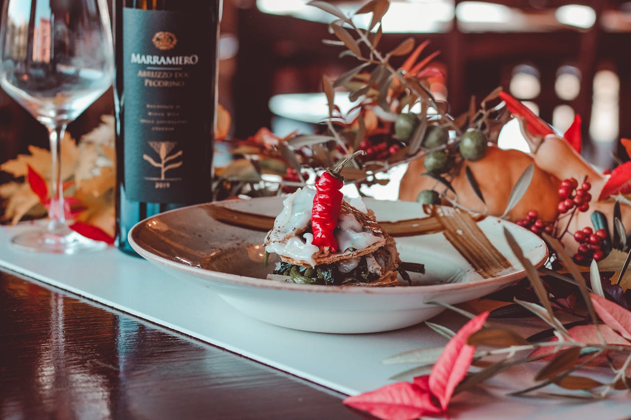 who-we-are Elegant presentation of gourmet dish with wine and autumn-themed table setting.